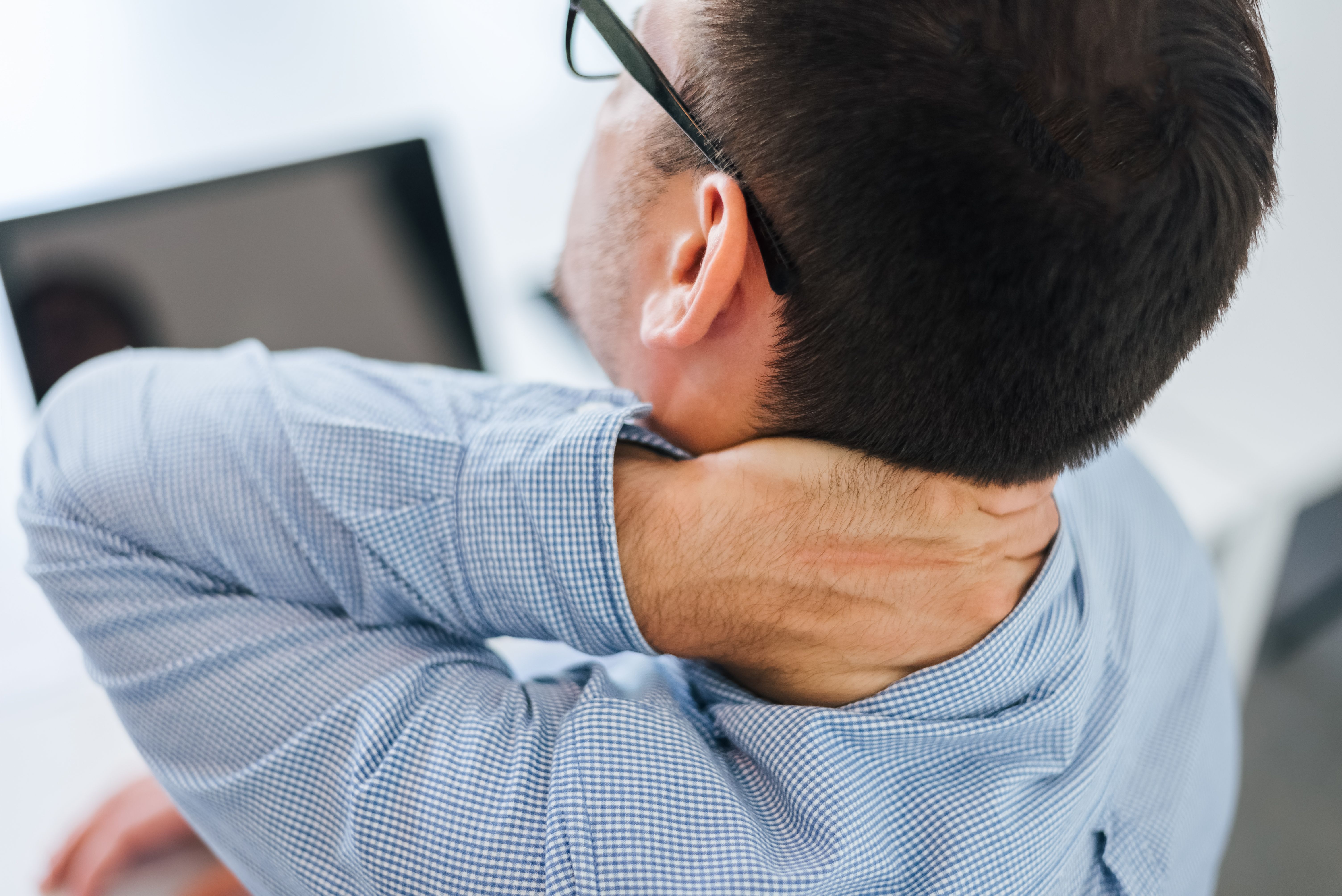 businessman office working holding sore neck pain from desk working sitting all day using laptop computer notebook suffering neck ache sick worker overworking concept copy space closeup