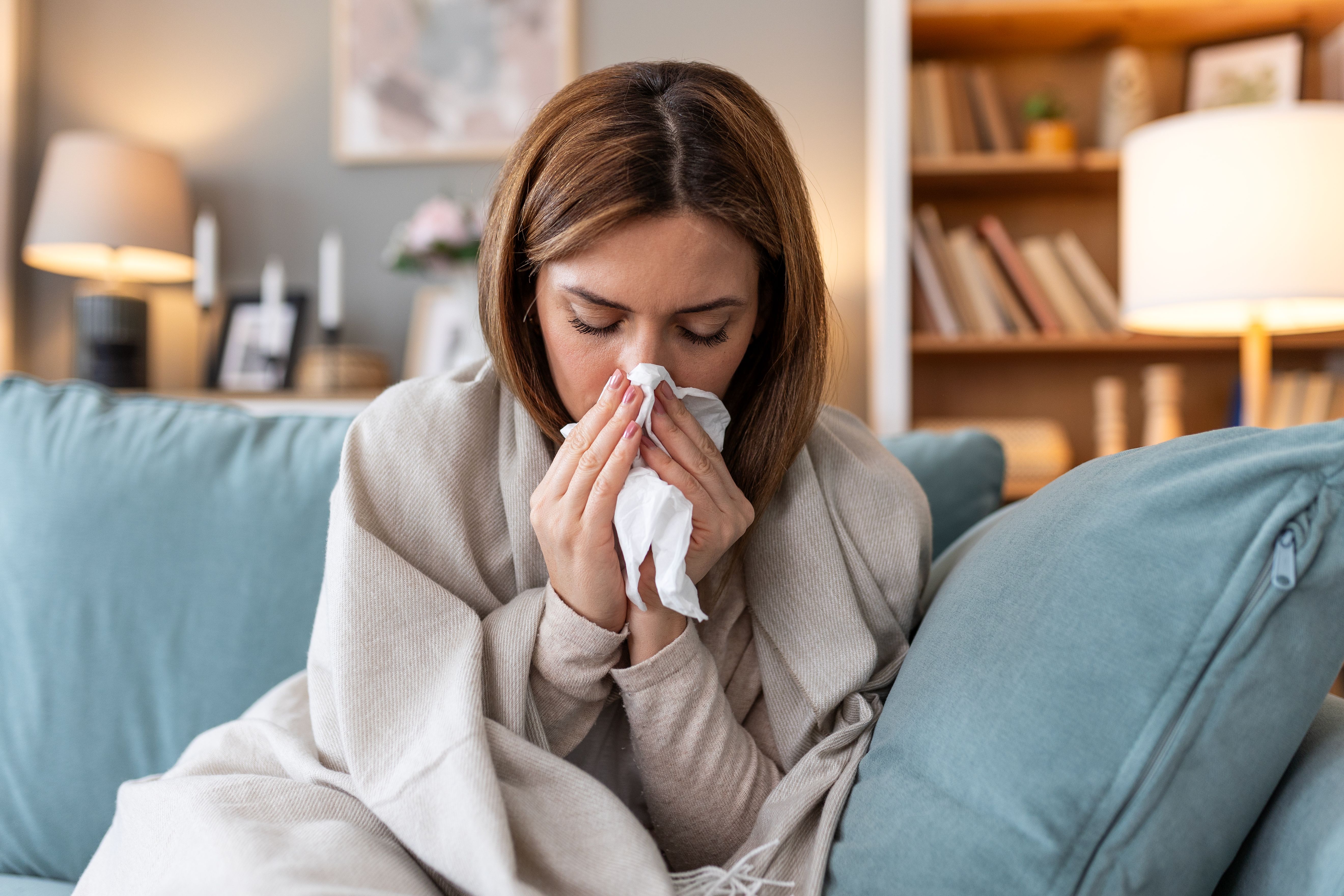 sickness seasonal virus problem concept woman being sick having flu lying sofa sick woman lying bed with high fever cold flu migraine